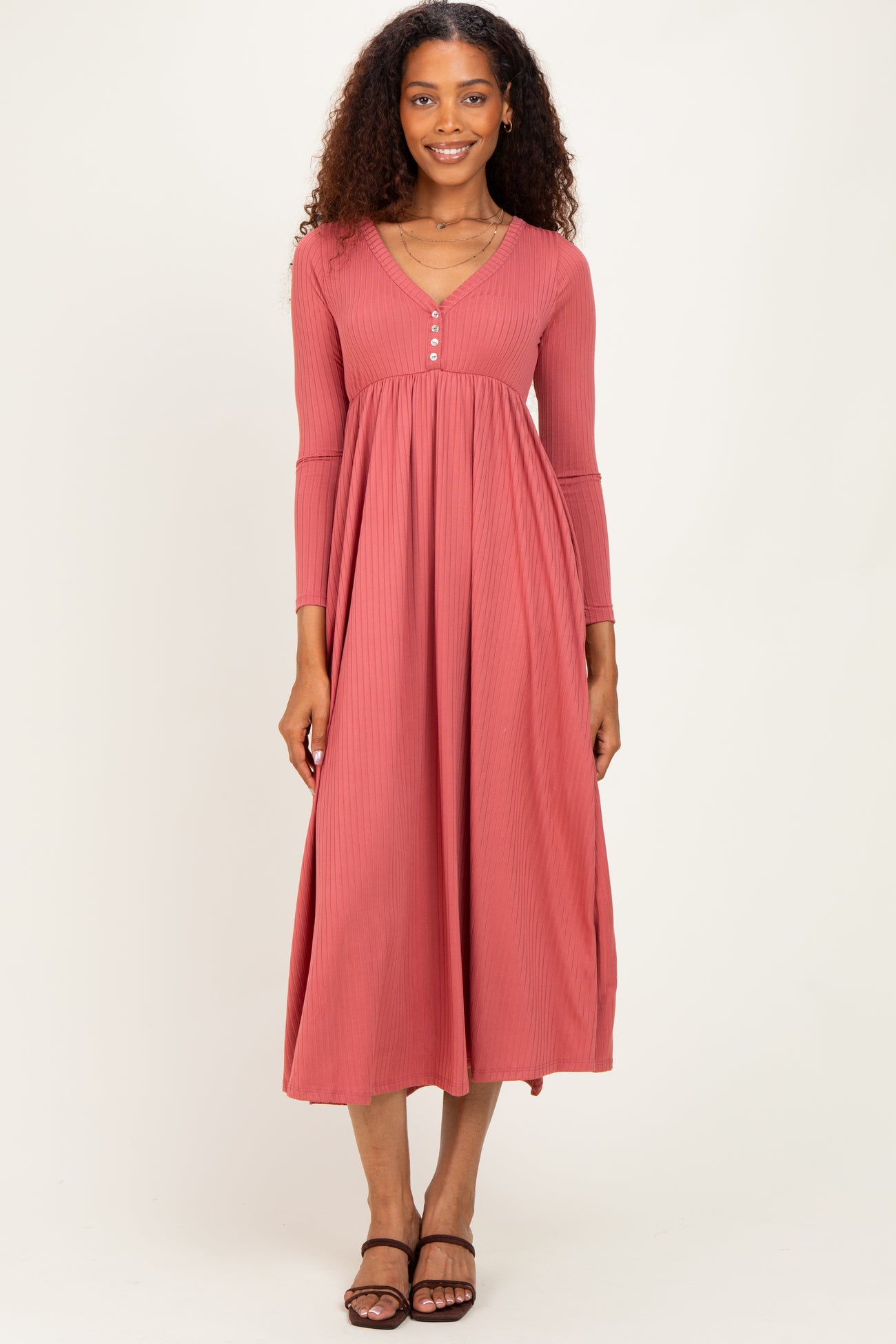 woman wearing a rust ribbed maxi dress with long sleeves and a button-down neckline
