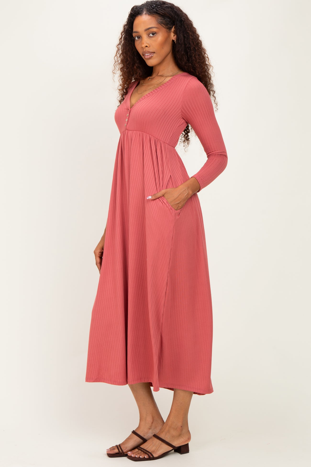 woman wearing a dusty rose long sleeve ribbed maxi dress with pockets and a v-neckline