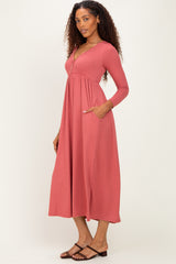 woman wearing a dusty rose long sleeve ribbed maxi dress with pockets and a v-neckline