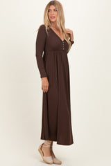 woman wearing a chocolate brown long sleeve maxi dress with a v-neckline and button details