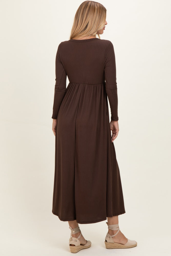 woman wearing a chocolate brown long sleeve maxi dress with a cinched waist and flowing skirt