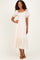 woman wearing a cream puff sleeve maxi dress with a square neckline and smocked bodice