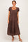 woman wearing a brown polka dot midi dress with short sleeves and a square neckline