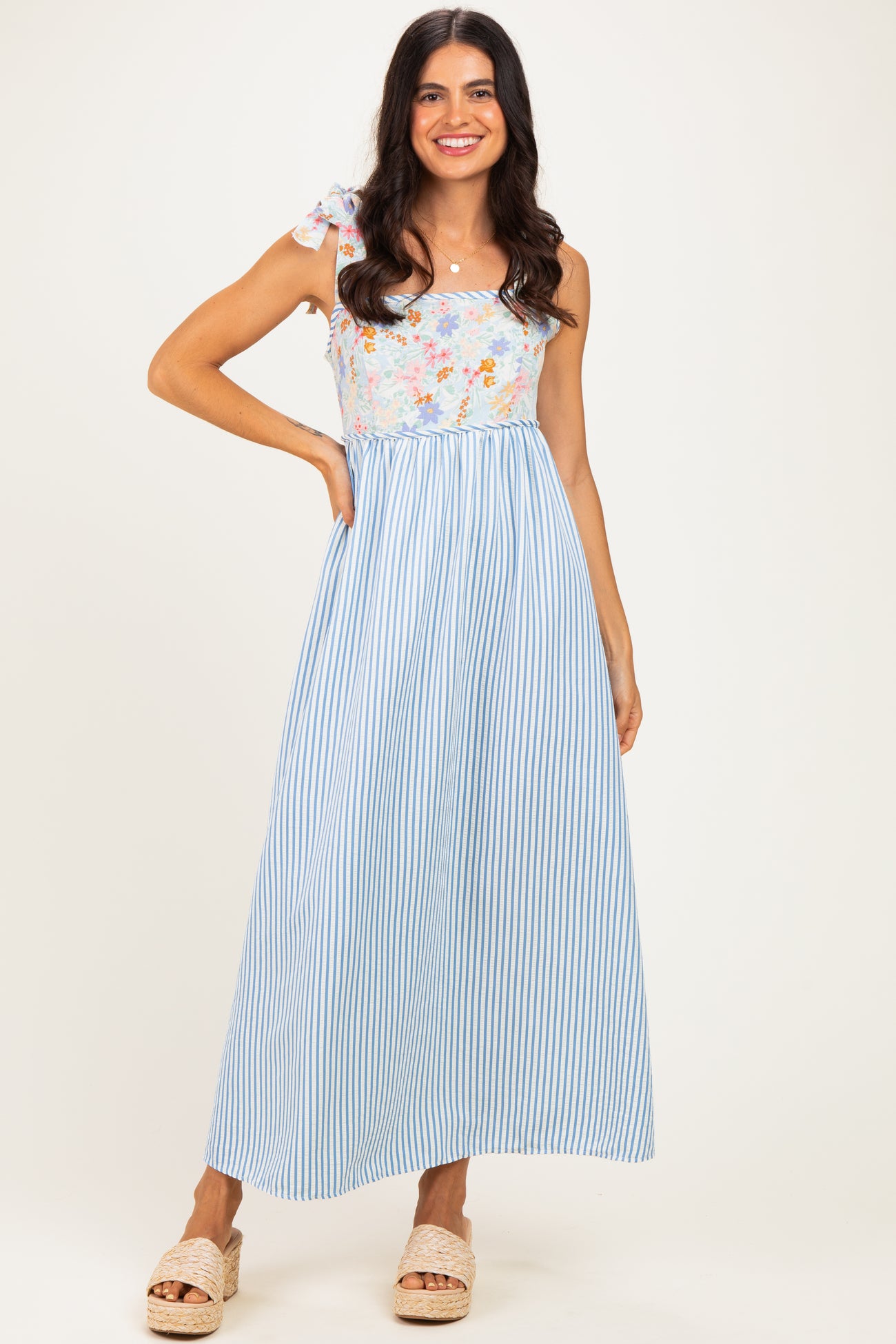 woman wearing a floral and striped maxi dress with tie shoulder straps and a relaxed fit