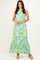 woman wearing a floral maxi dress in greens and yellows with a halter neck and tiered hem