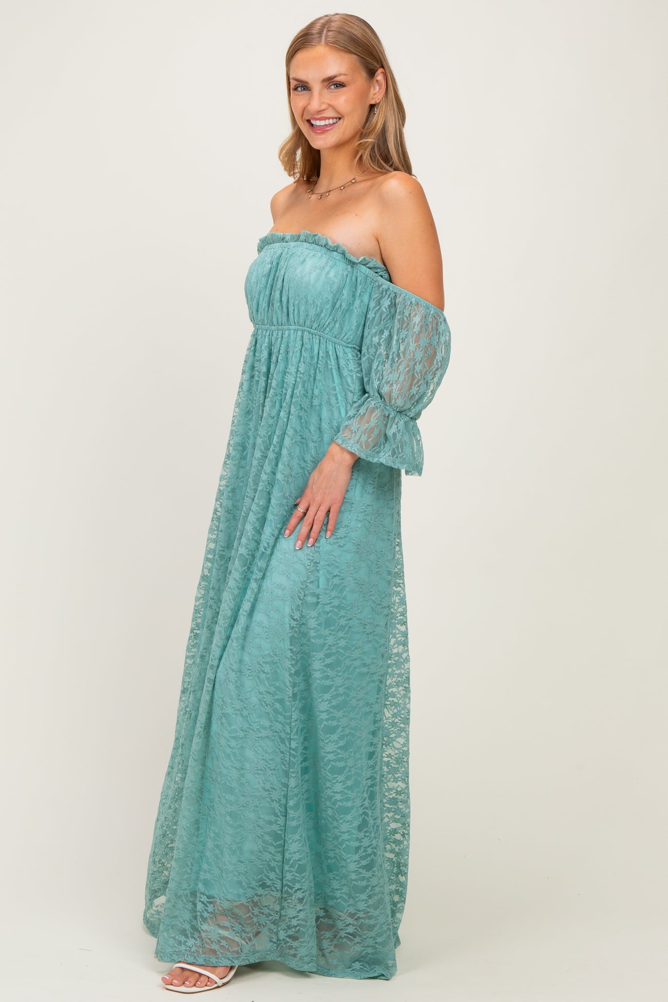 woman wearing a teal off-the-shoulder lace maxi dress with long flared sleeves