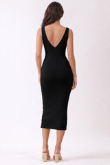 woman wearing a black ribbed midi dress with a deep v-back and fitted silhouette