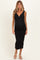 woman wearing a black ribbed maternity dress with a v-neckline and a visible baby bump