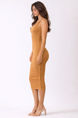 woman wearing a mustard ribbed midi dress with a fitted silhouette and sleeveless design