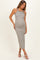 woman wearing a grey and white striped maternity dress with a fitted silhouette and side slit, showing her baby bump