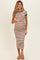 woman wearing a brown and cream striped maternity dress, gently cradling her baby bump