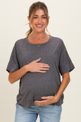 woman wearing a dark gray short sleeve maternity top and holding her baby bump
