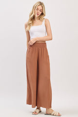 woman wearing a white square neck tank top and rust-colored wide leg pants
