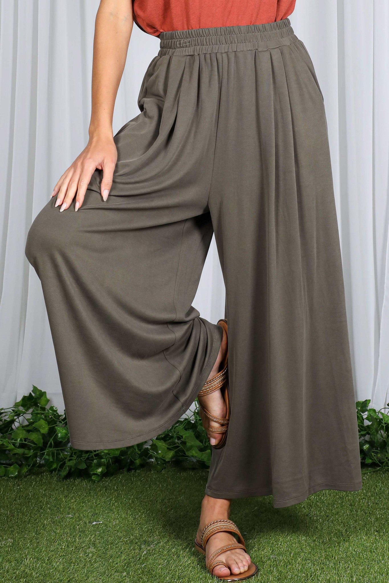 woman wearing olive green wide-leg pants with a comfortable elastic waistband and a relaxed fit