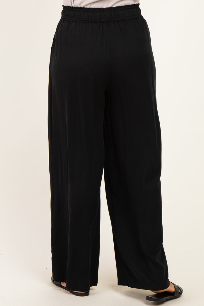 woman wearing black wide-leg trousers with an elastic waistband, shown from the back