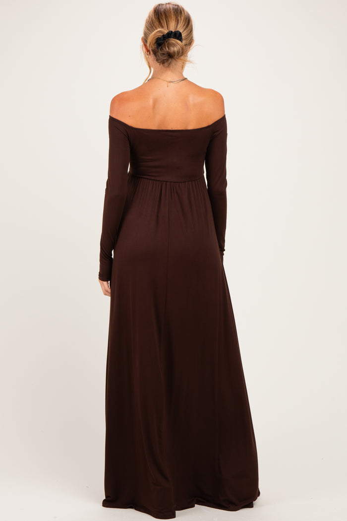 woman wearing a chocolate brown off-the-shoulder maternity maxi dress, showing a flowing silhouette from behind
