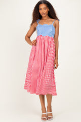 woman wearing a blue and red gingham midi dress with spaghetti straps and a tiered design