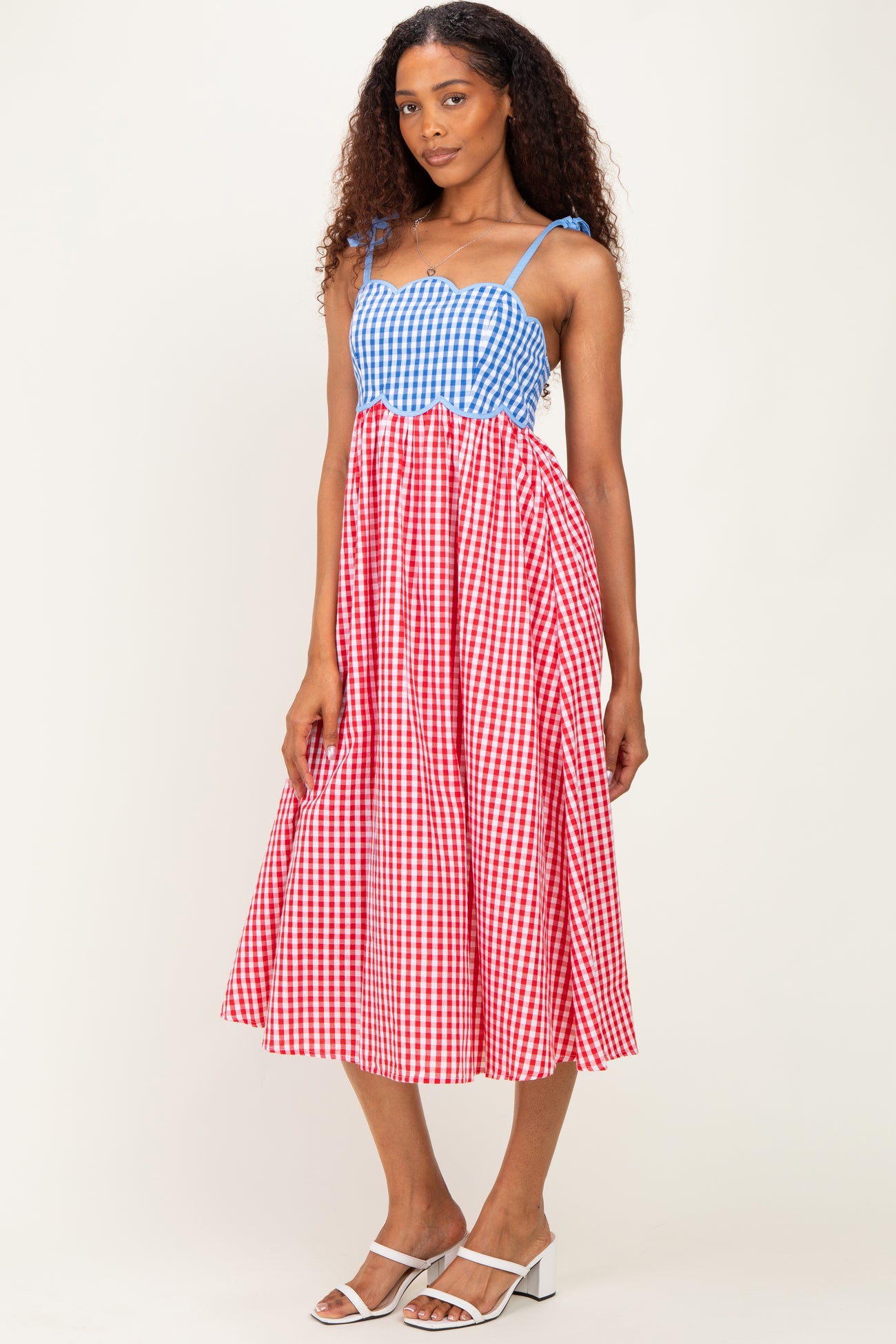 woman wearing a blue and white gingham top and red and white gingham skirt midi dress with spaghetti straps