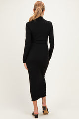 woman wearing a black long sleeve ribbed maternity dress, view from the back, fitted style