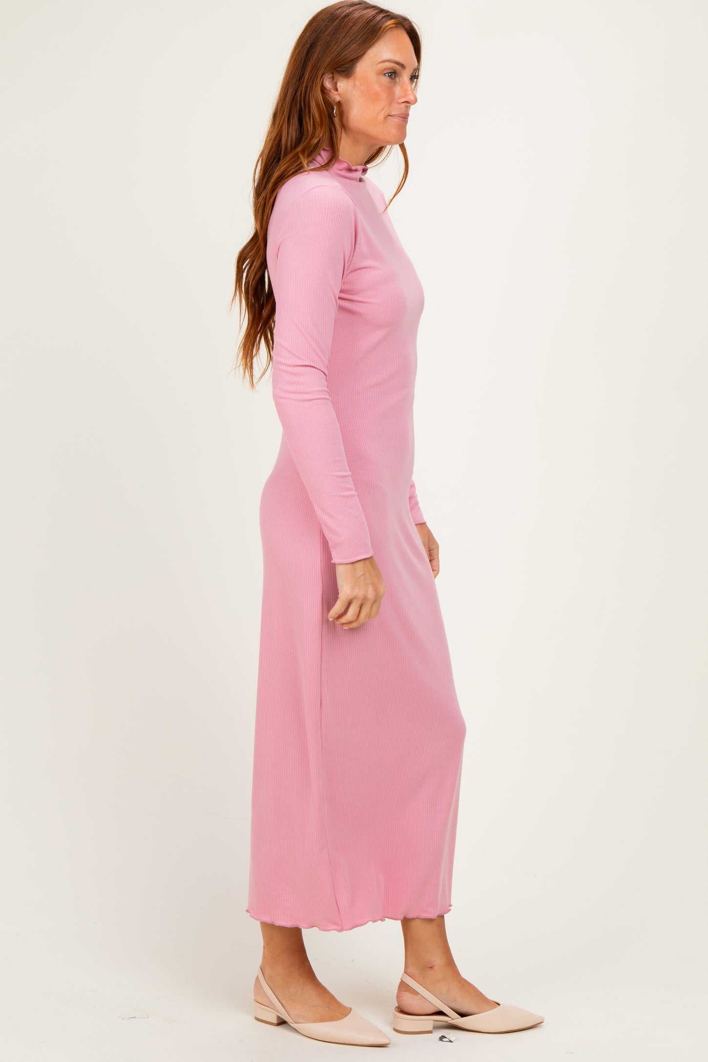 woman wearing a light pink long sleeve maxi dress with a high neckline and a relaxed fit