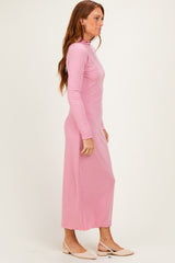 woman wearing a light pink long sleeve maxi dress with a high neckline and a relaxed fit
