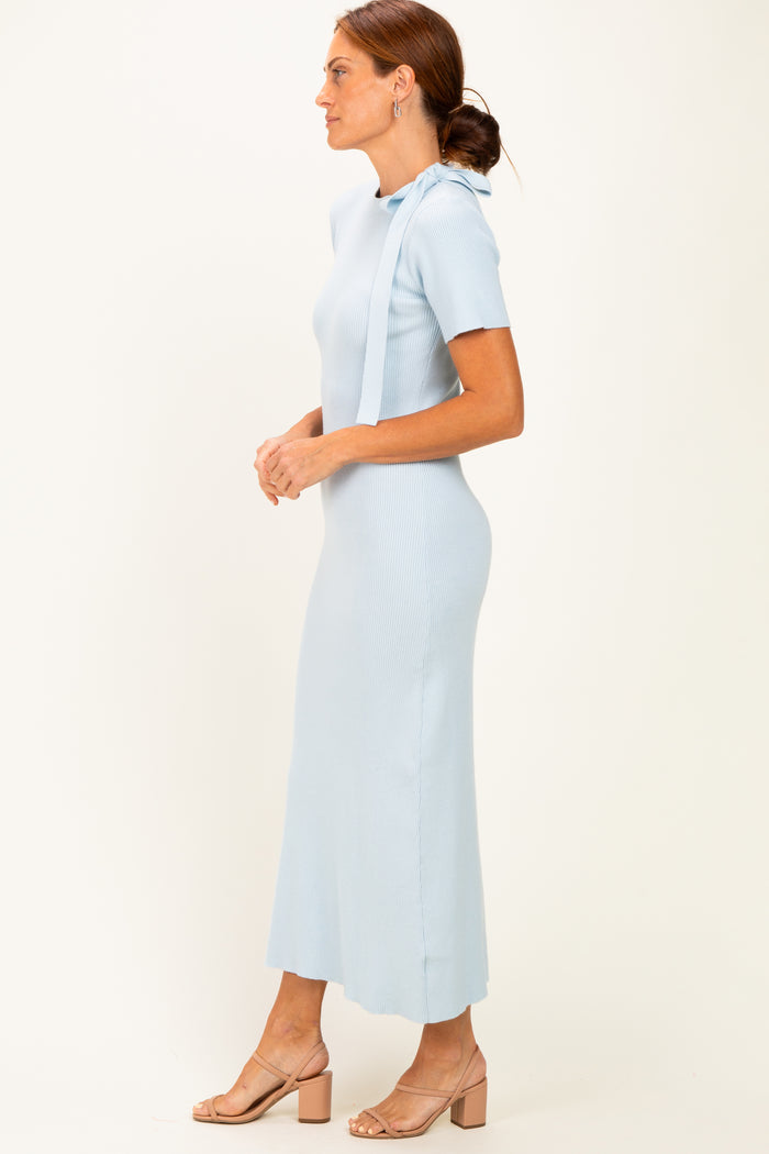 woman wearing a light blue ribbed knit maxi dress with short sleeves and side slits, standing sideways