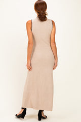woman wearing a beige sleeveless ribbed maxi dress from the back with a side slit and black heels