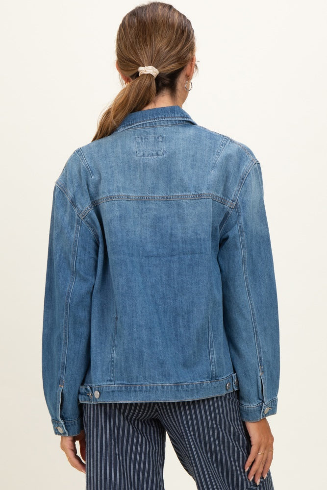 woman wearing a light blue denim maternity jacket, seen from the back with long sleeves and relaxed fit