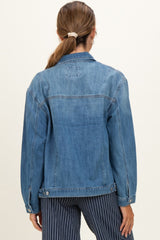 woman wearing a light blue denim maternity jacket, seen from the back with long sleeves and relaxed fit