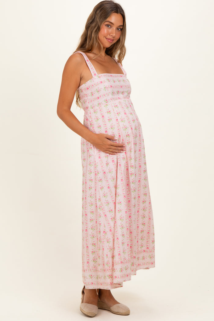 woman wearing a pink floral maternity maxi dress with adjustable straps and a baby bump