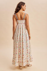 woman wearing a floral print maxi dress with spaghetti straps and a smocked back
