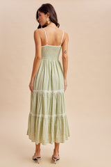woman wearing a green midi dress with a smocked bodice and tiered skirt, shown from the back