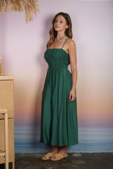 woman wearing a green smocked maxi dress with spaghetti straps and a fitted bodice