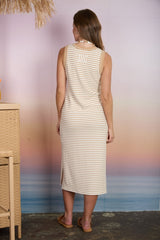 woman wearing a beige and white striped sleeveless midi dress with a slit on the side, seen from the back