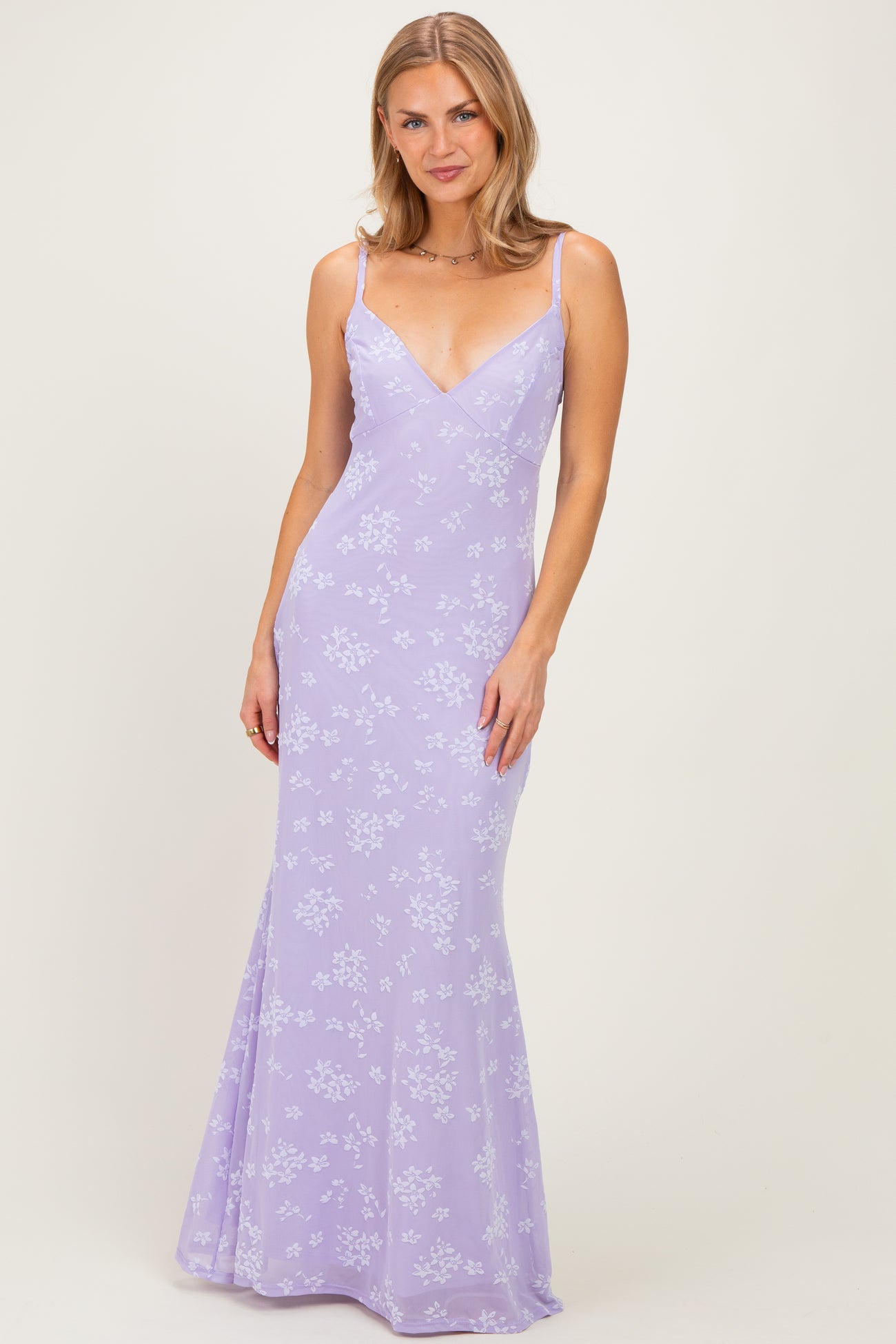 woman wearing a lavender floral print evening gown with a fitted silhouette and spaghetti straps