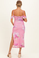 woman wearing a pink floral maternity dress with cold shoulder sleeves and a side slit