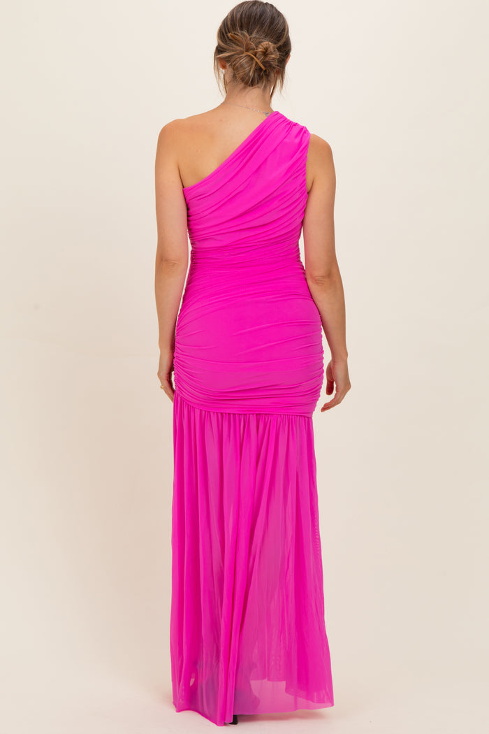 woman wearing a bright pink one-shoulder maternity gown with ruching and a flowing skirt