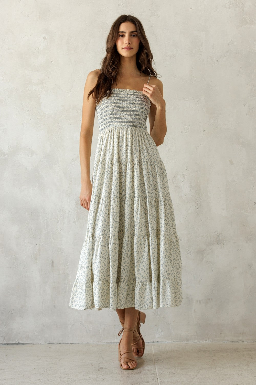 woman wearing a floral print strapless maxi dress with a smocked bodice and tiered skirt