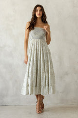 woman wearing a floral print strapless maxi dress with a smocked bodice and tiered skirt