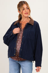 woman wearing a navy blue corduroy maternity jacket with a brown collar and holding her baby bump