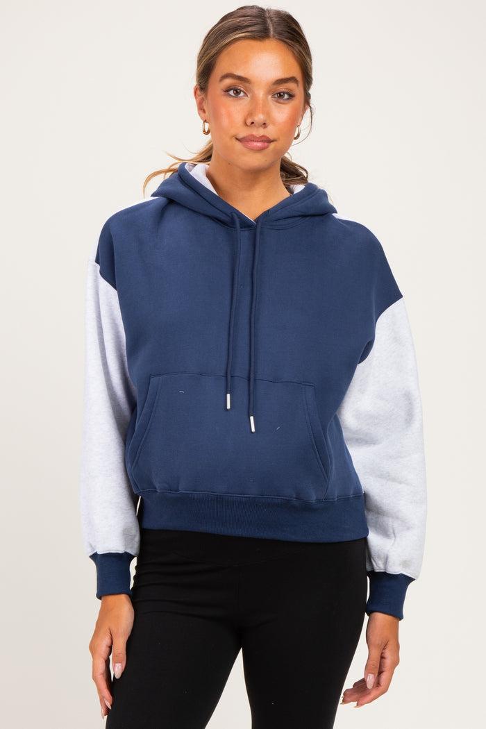 woman wearing a navy and gray color block maternity hoodie with a front pocket and hood