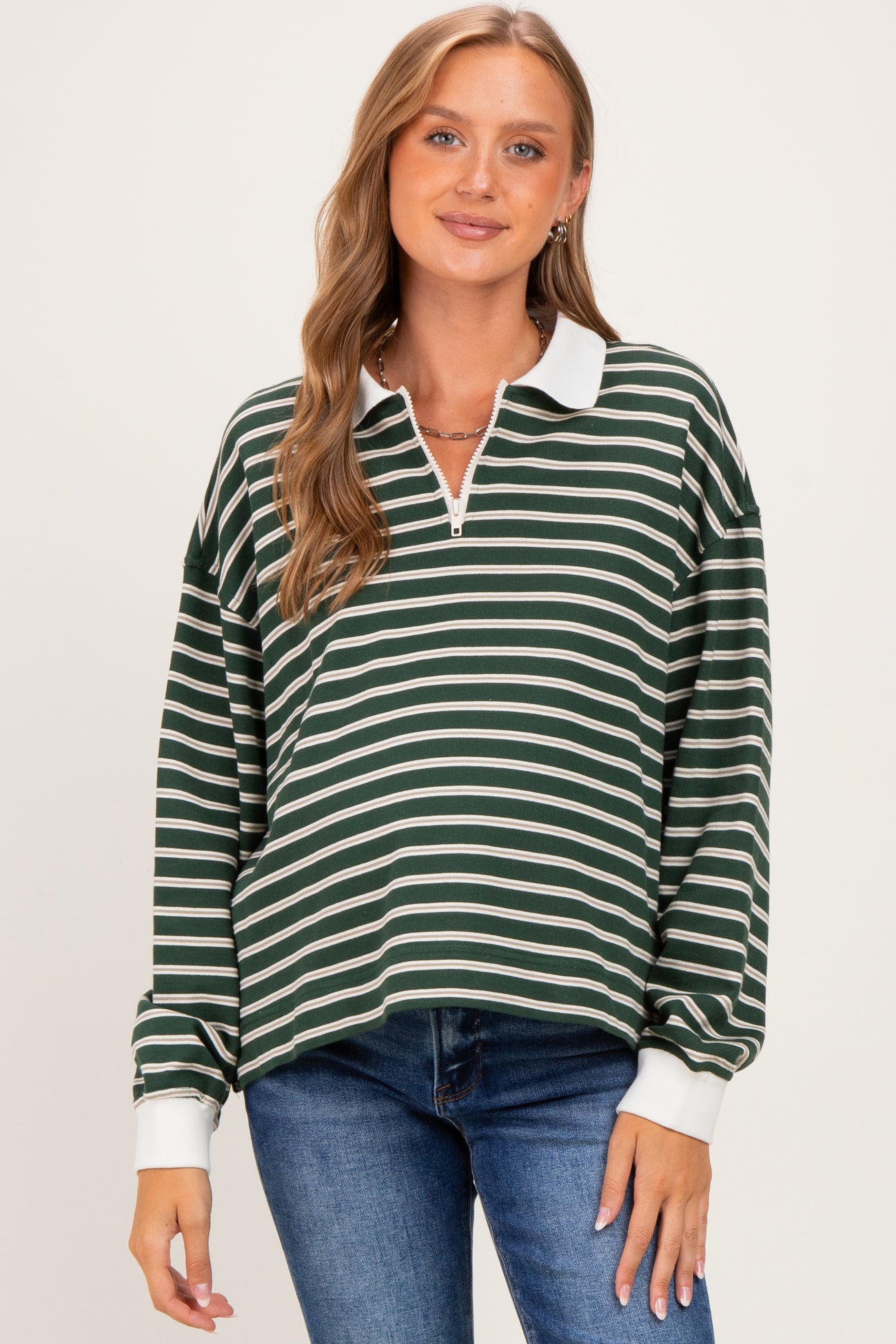 woman wearing a green and white striped long sleeve maternity top with a collar and a relaxed fit