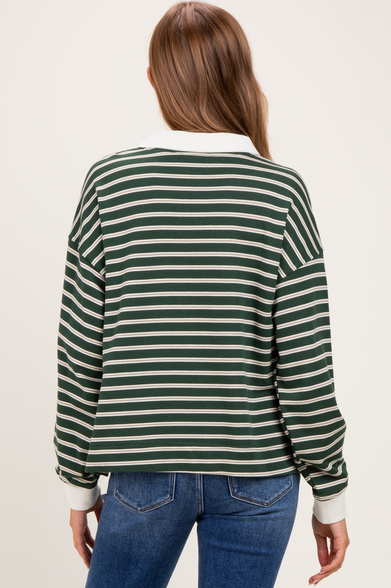 woman wearing a green and white striped maternity sweatshirt with a collared neckline and long sleeves, viewed from the back