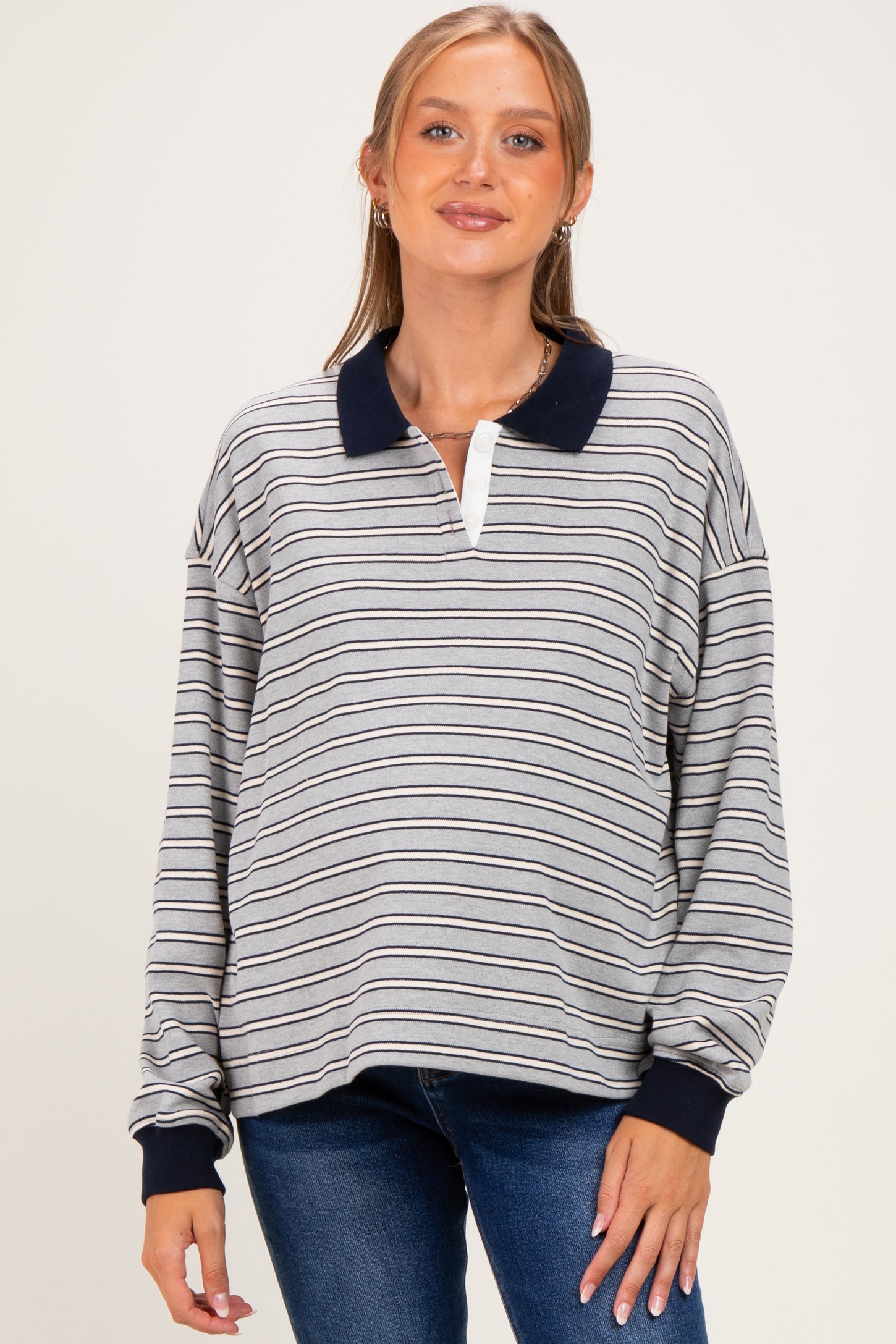 woman wearing a striped maternity pullover with a navy collar and a visible baby bump