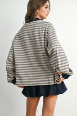 woman wearing a beige and navy striped oversized jacket with a relaxed fit and paired with a dark skirt