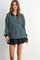 woman wearing a navy and green striped long sleeve polo top paired with a navy skirt