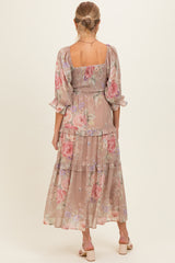 woman wearing a floral patterned maternity maxi dress with a smocked bodice and tiered skirt, showing a baby bump from behind