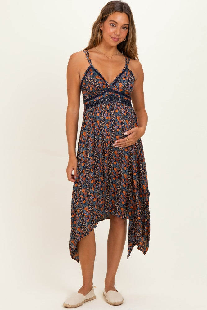 woman wearing a navy blue floral maternity dress with an asymmetrical hemline and holding her baby bump