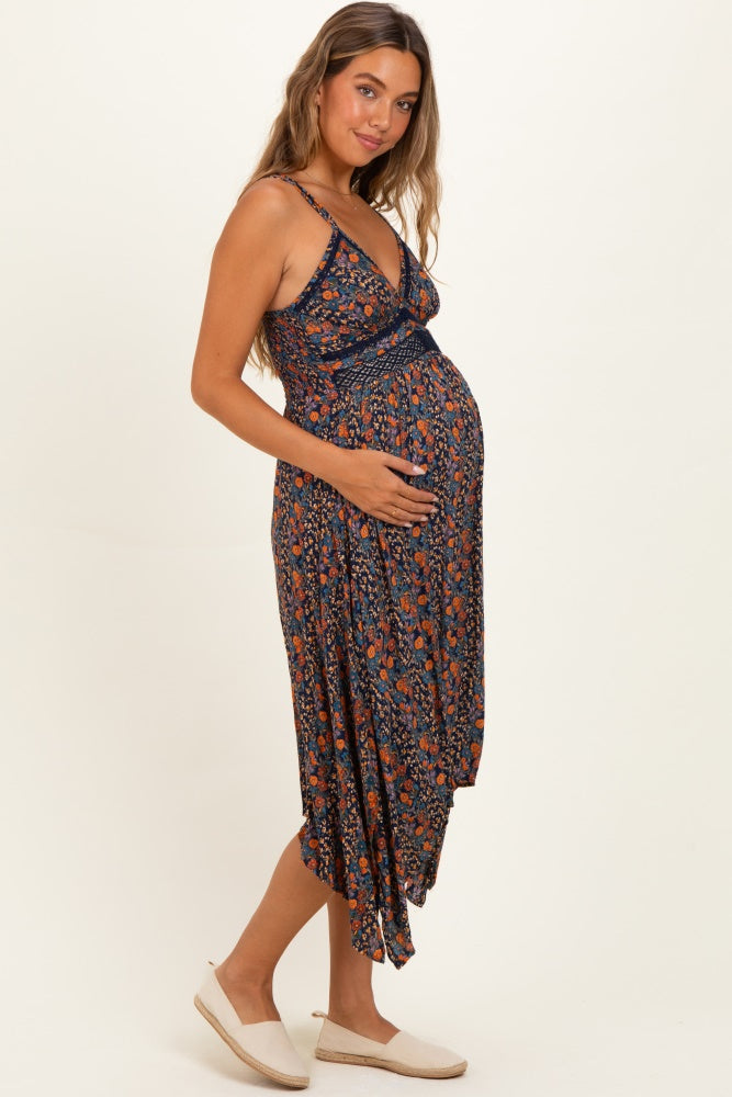 woman wearing a navy floral maternity dress with a wrap design and holding her baby bump