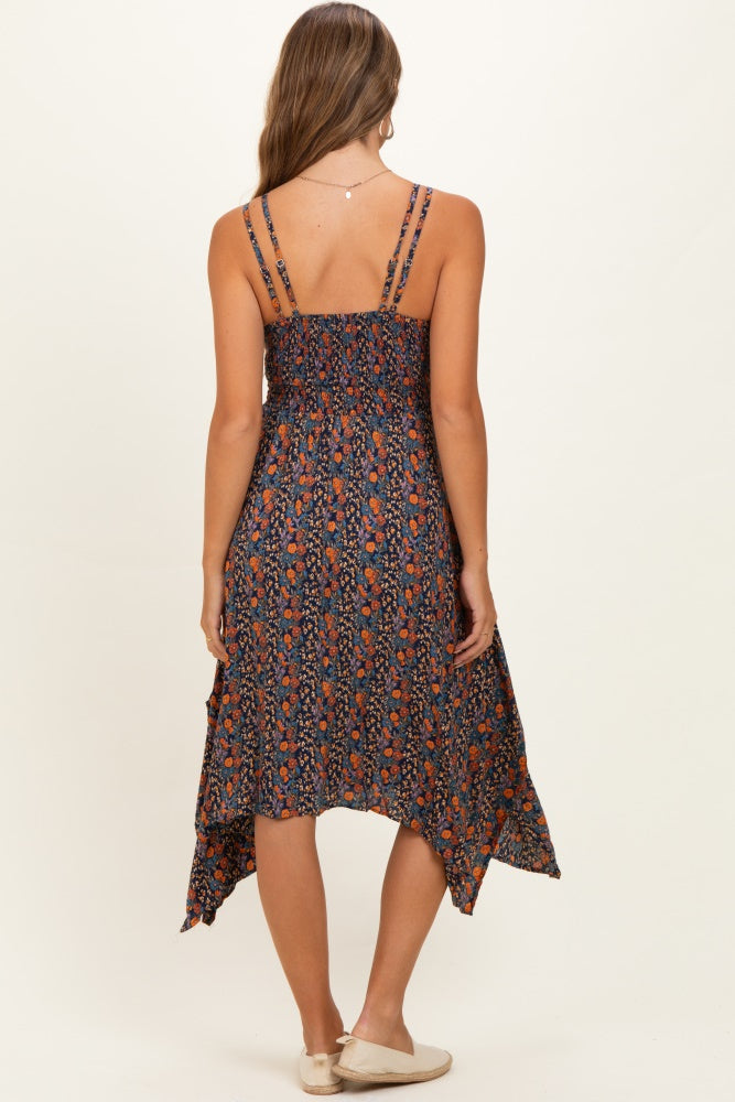 woman wearing a dark floral maternity dress with adjustable straps and a high-low hemline